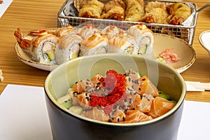 Black and green bowl with marinated salmon, red fish roe, avocado and sesame. photo