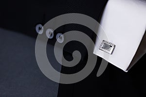 Cufflink and suit on the grey background