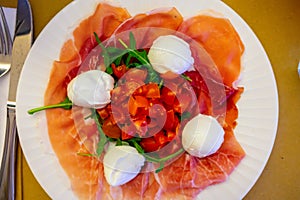 Cuisine of Emilia-Romagna region, Caprese salad with Prosciutto crudo, prosciutto di Parma, mozzarella cheese and tomatoes, lunch photo