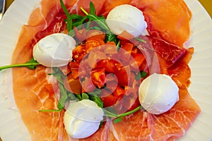 Cuisine of Emilia-Romagna region, Caprese salad with Prosciutto crudo, prosciutto di Parma, mozzarella cheese and tomatoes, lunch photo