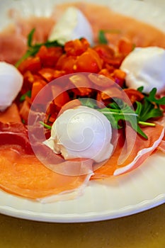 Cuisine of Emilia-Romagna region, Caprese salad with Prosciutto crudo, prosciutto di Parma, mozzarella cheese and tomatoes, lunch