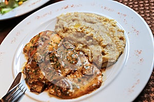 Cuisine specialty in Swiss Ticino and Grisons - Polenta Rosso with meat pieces and boletus mushroom