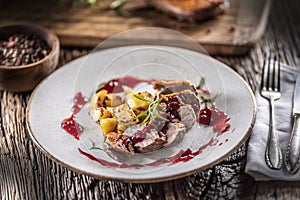 Culinarily prepared duck breast with baked potatoes and cranberry cauce photo