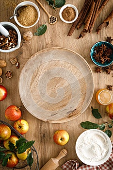Culinary background. Cooking Thanksgiving autumn apple pie with fresh fruits and walnuts on wooden table.