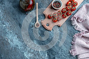 Culinary background with empty wooden cutting board, composition of oil, chili peppers, cherry tomatoes sprig and spices. banner,