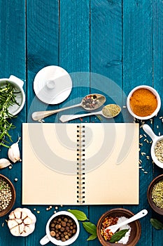 Culinary background and recipe book with spices on wooden table