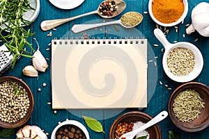 Culinary background and recipe book with spices on wooden table