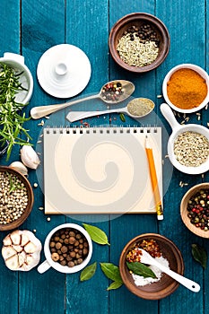 Culinary background and recipe book with spices on wooden table