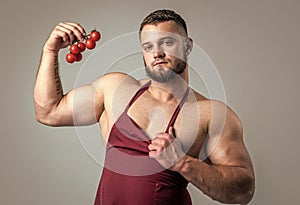 culinary and cuisine. muscular man eat vitamins. guy eating healthy. food for athletes. sexy man with tomato vegetable