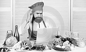 Culinary education online. Elearning concept. Man chef searching internet recipe cooking food. Chef laptop read culinary