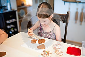 Culinary workshops for children and gingerbread decorating. Young girl decorating gingerbread cookies