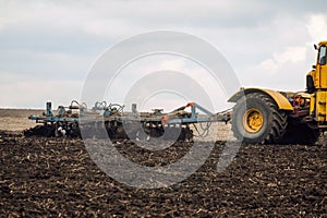 Cultivation of the soil with a disc harrow attached to a tractor