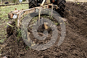 Cultivation with tractor of black fertile soil in Northern Europe in the end of the autumn. Preparing land for winter.