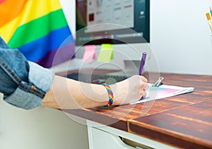 Cultura LGBTQIA. Woman working in office with LGBT accessories photo