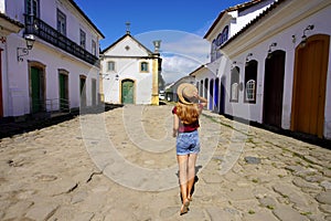 Cultural tourism in Brazil. Travel woman walking towards the chapel of Nossa Senhora dos Remedios e Sao Benedito in the historic photo