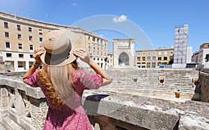 Cultural tourism in Italy. Beautiful tourist girl visiting ruins of Roman Amphitheater of the city of Lecce, Italy
