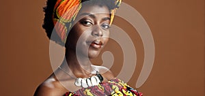 Culture, African fashion or face of black woman in studio on a brown background for trendy style. Unique, beauty or