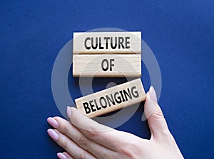 Culture of Belonging symbol. Wooden blocks with words Culture of Belonging. Beautiful deep blue background. Business and Culture