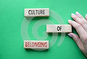 Culture of Belonging symbol. Wooden blocks with words Culture of Belonging. Beautiful green background. Business and Culture of