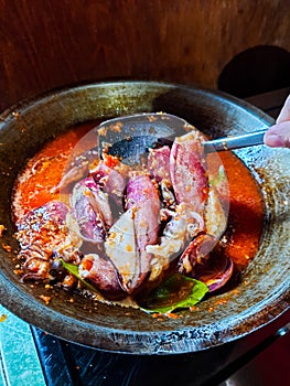 Cumi Balado or red chili squid. one of the typical Minangkabau dishes in Indonesia, fresh squid cooked with spicy chili sauce.