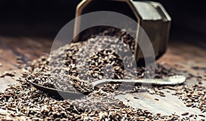 Cumin.Caraway seeds on wooden table. Cumin in vintage bronze bowl and spoon