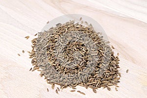 Cumin isolated on a wooden background. Caraway seeds. Heap of cumin