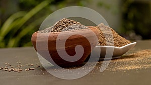 Cumin seeds called Jeera in clay bowl and it`s powder in white bowl on dark background.