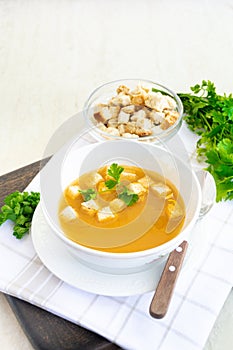 Cumin soup served in a white dish with croutons and parsley