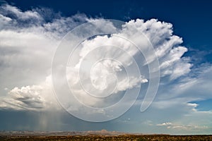 Cumulonimbus cloud with rain falling and blue sky