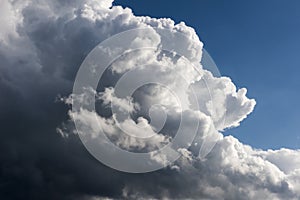 Cumulonimbus clouds from upcoming thunderstorm. Wind piles up the clouds. Heavy rain clouds in sky.