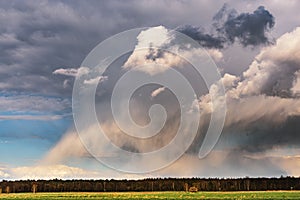 A cumulonimbus storm cloud over the fields and convective rainfall.