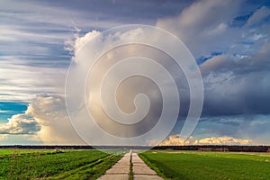 A cumulonimbus storm cloud over the fields and convective rainfall.