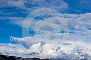 Cumulos, nimbus, clouds with angeles crest mountains, blue sky, sunlight, photo