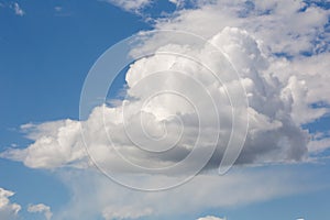 A cumulus cloud in the blue sky on a clear sunny day