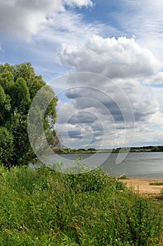 Cumulus clouds. Landscape with the Volkhov River.