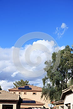 Cumulus Clouds Rise above House Roofs