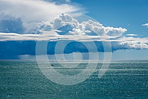 Cumulus Clouds with Torrential Rain on the Horizon over the Sea