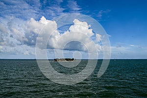 Cumulonimbus clouds in wing shape over island in Caribbean Sea photo