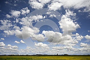 Cumulus type clouds cover the blue sky.