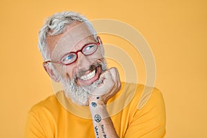 Cunning excited older funny man waiting with anticipation isolated on yellow.