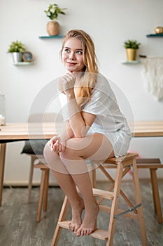 A cunning girl is thinking on the chair