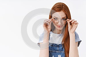 Cunning good-looking redhead sassy girlfriend put on glasses look from under forehead devious pleased have something