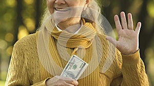 Cunning old woman holding money, cheating state, getting double welfare benefit