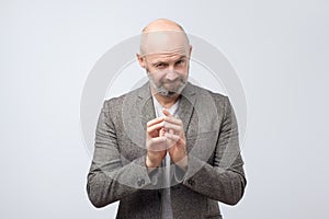 Cunning tricky mature man thinking with hand together over white background.