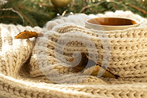 Cup of autumn coffee, tea or hot chocolate, fall leave on a warm scarf. Drink for autumn cold rainy days. Seasonal