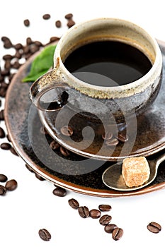 Cup of black coffee with beans on white background