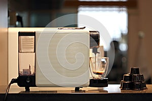 A Cup of Black Coffee Being Prepared with Capsule Coffee Machine