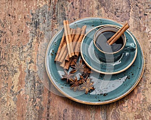 Cup of black coffee with cinnamon and star anise spices