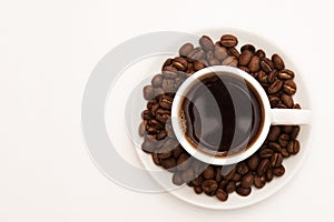 Cup of black coffee with coffee beans.
