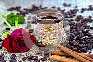 Cup of black coffee with coffee beans, red rose .